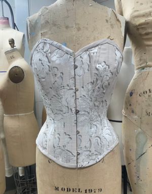 front view of a silver corset created by Kristy Zou